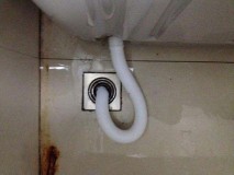 洗衣机出水管太长怎么收纳（洗衣机下水管固定在墙上收纳）